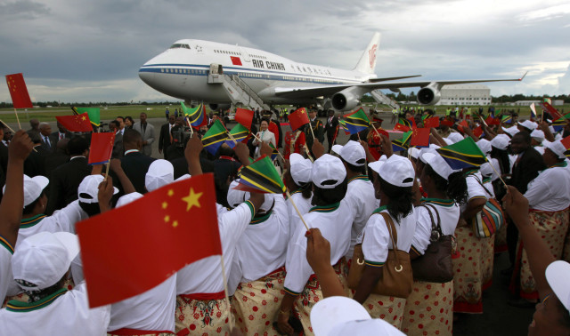 Tanzanian women cheer as they welcome China's President Xi during his arrival at Julius Nyerere International Airport in Dar es Salaam